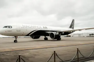 Magnifica Air Airbus on the tarmac, clouds in the background.