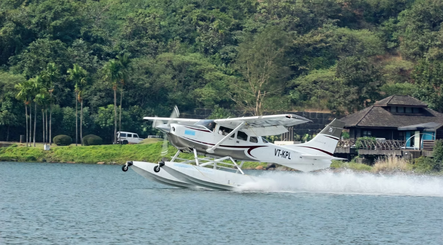 Mehair seaplane aircraft in the water, trees in the background.