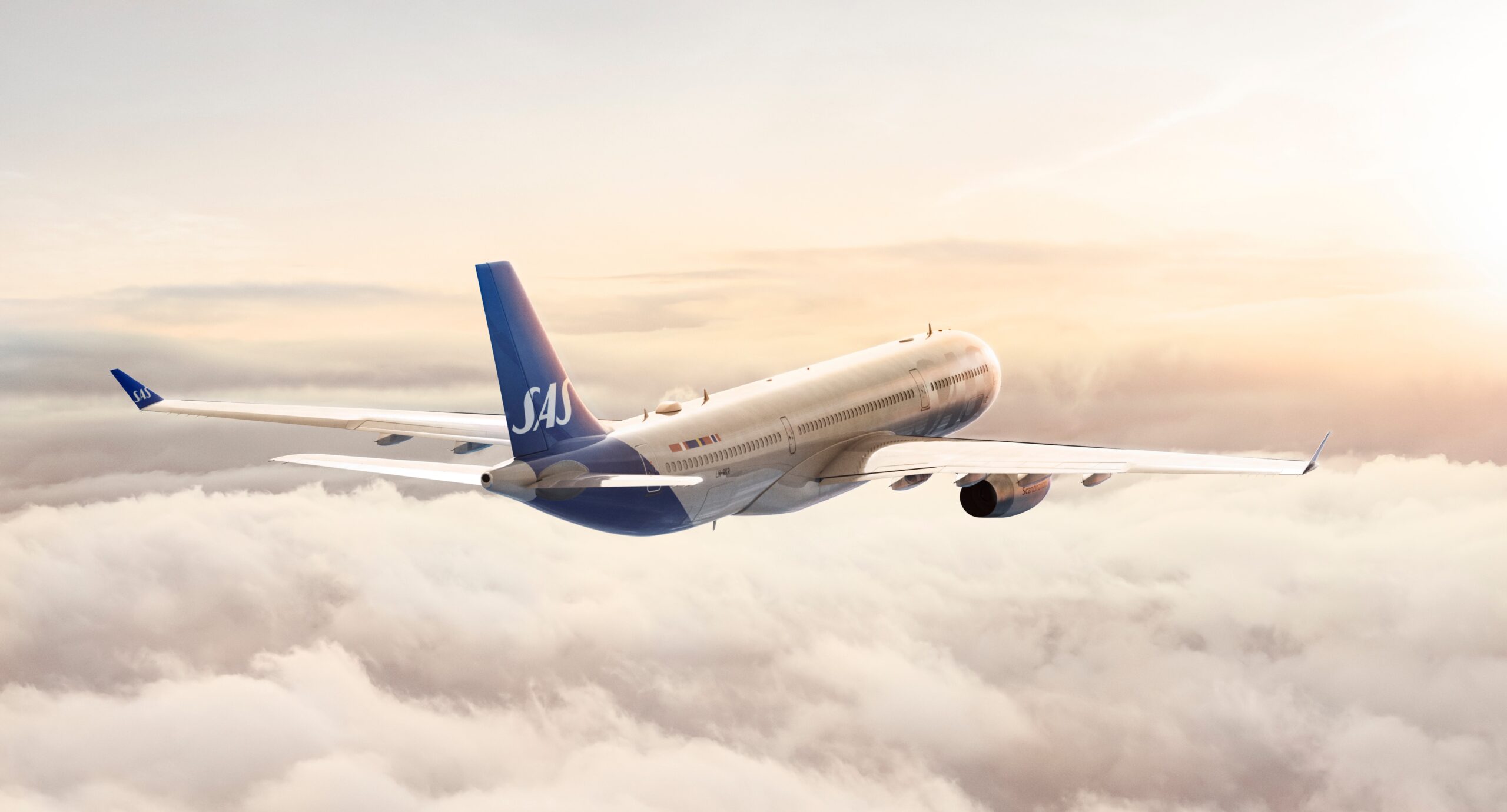 An image of an SAS A330 aircraft above the clouds with the sun setting