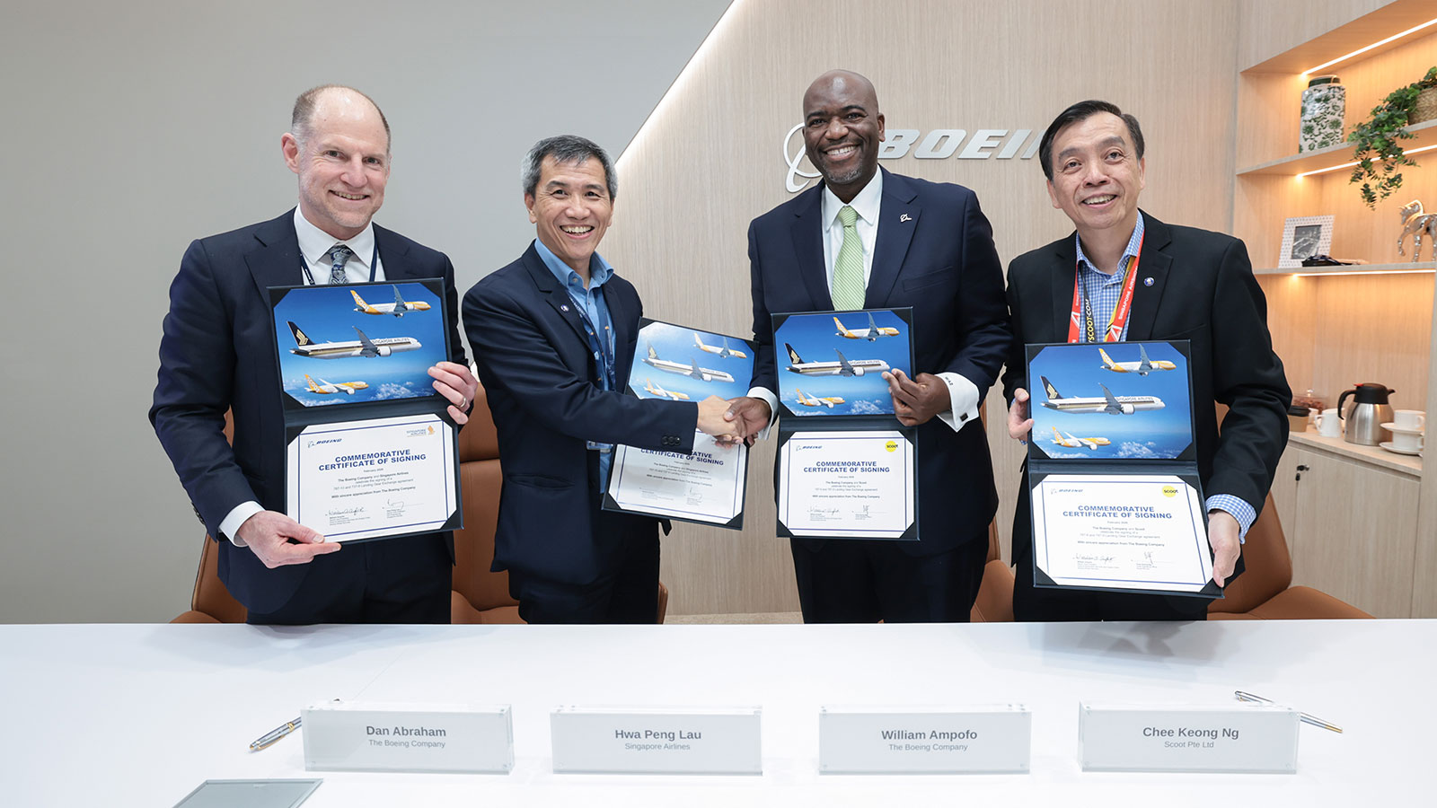 Singapore Airlines Group members shaking hands with Boeing employees after signing contract.