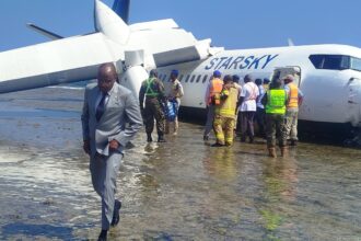 Aftermath of landing, depicting plane submerged in water on the beach.