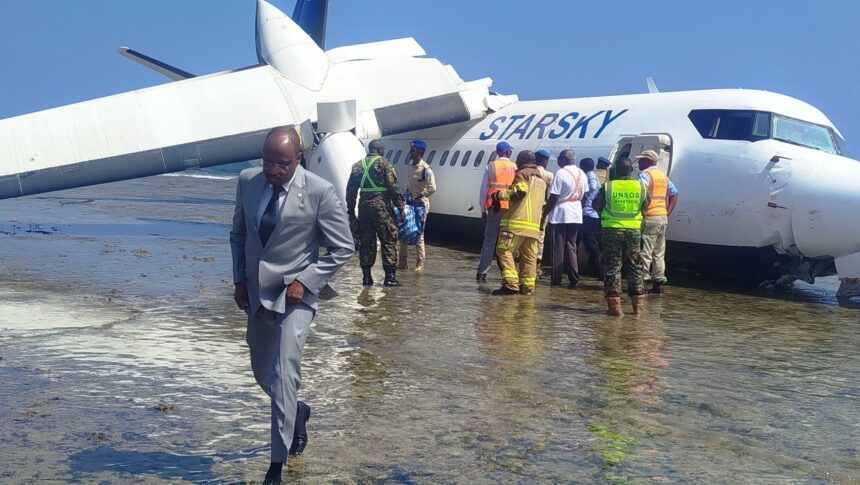 Aftermath of landing, depicting plane submerged in water on the beach.