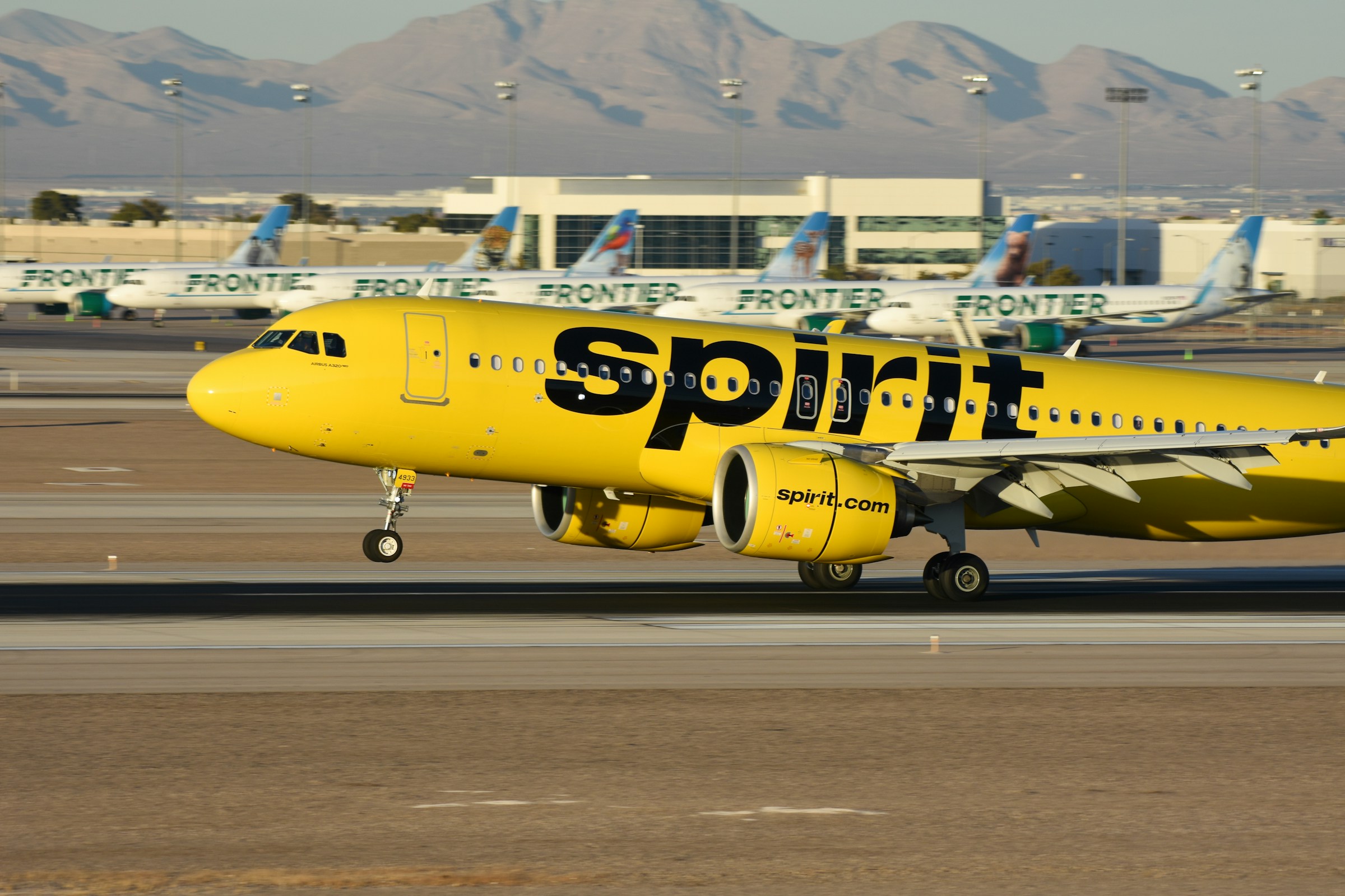 Spirit Airlines A320neo landing in Las Vegas with Frontier Airlines jets in the background