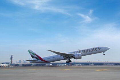 An Emirates Boeing 777-300ER aircraft in new livery taking off from Dubai International Airport runway.