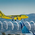 Spirit Airlines aircraft Flying with mountain on the background.
