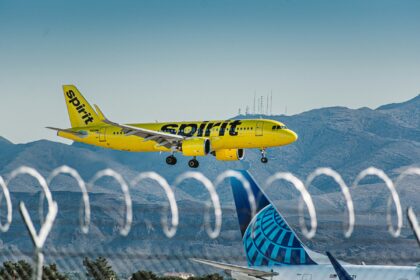 Spirit Airlines aircraft Flying with mountain on the background.