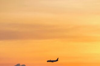 Airplane Silhouette Against Vibrant Sunset Sky