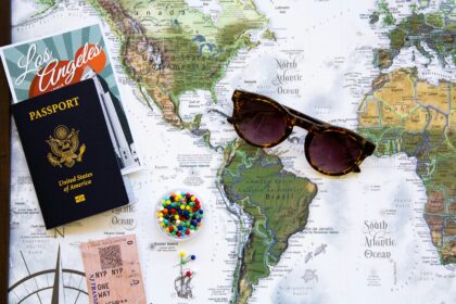 A map of USA with sunglasses and a passport on top of it.