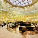 An interior airport lounge bathed in yellow lights.