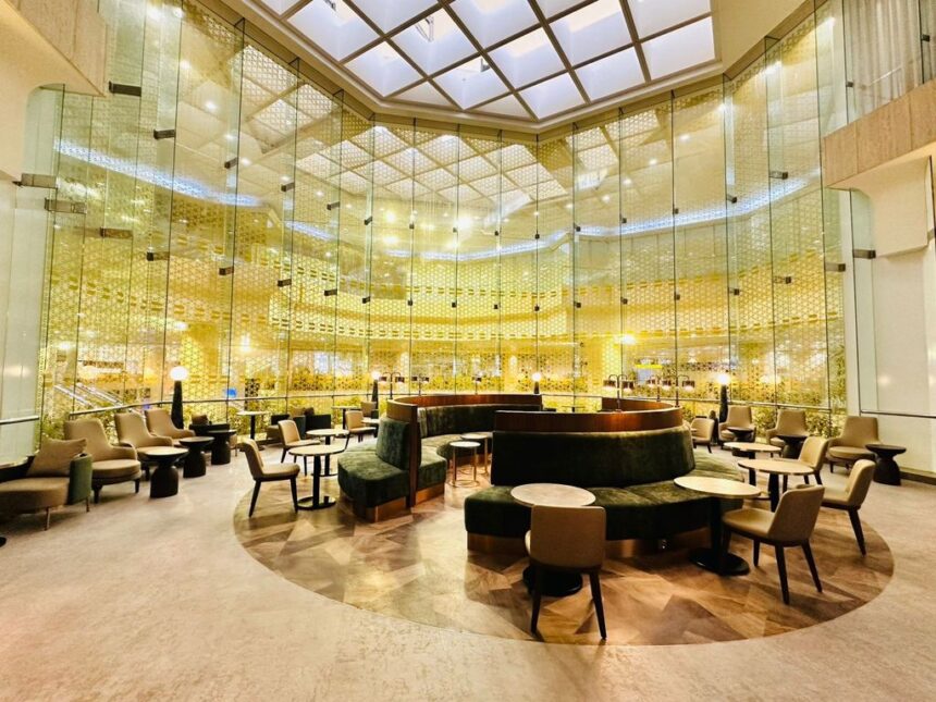 An interior airport lounge bathed in yellow lights.