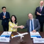 Airbus and Tigerair Taiwan signing documents and shaking hands.