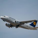 Lufthansa aircraft, flying in the grey sky.