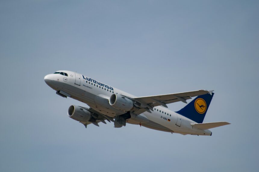 Lufthansa aircraft, flying in the grey sky.