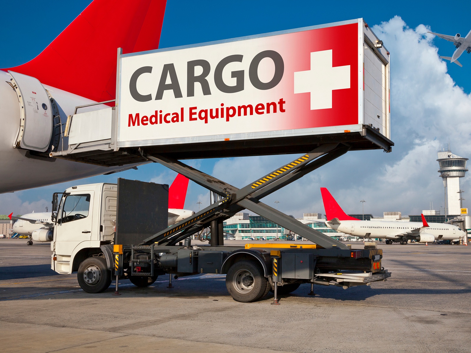 Airport high loader loading medical equipment cargo into airplane