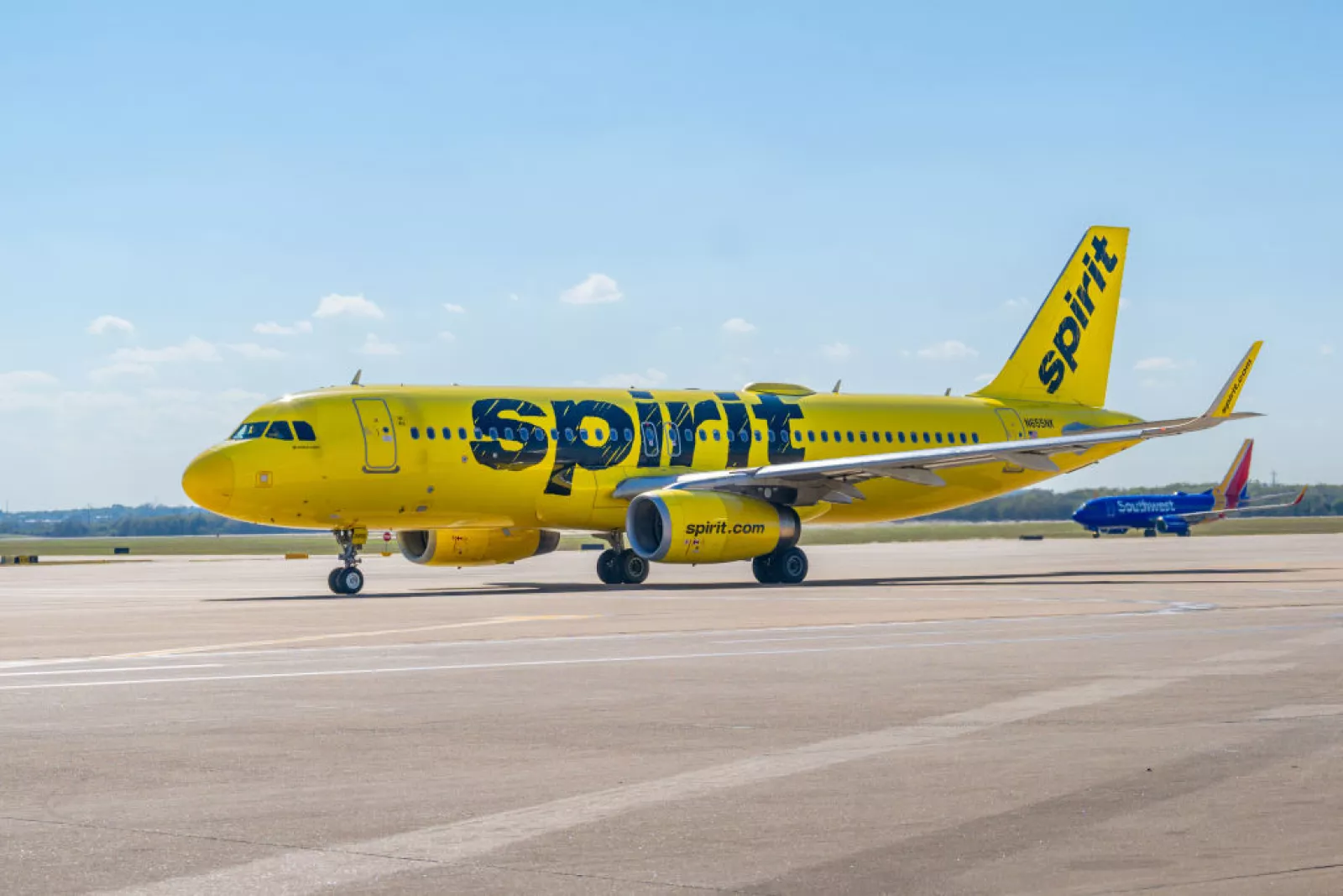 Spirit Airlines' A320neo on tarmac under blue skies.