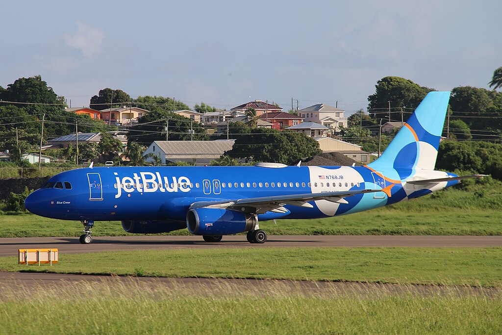 JetBlue Airbus A320 landed in front of houses under a blue sky