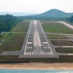 Runway of Phuket International Airport, with vegetation all around.