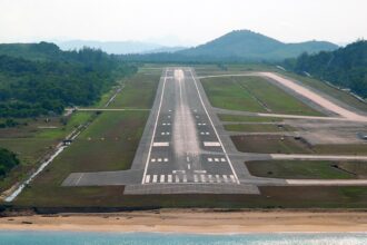 Runway of Phuket International Airport, with vegetation all around.