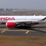 A sleek white Air India Airbus A350-900 taxis along a runway at an airport.