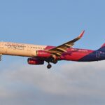 Wizz Air A321 aircraft flying under a blue sky