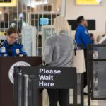 A Transportation Security Administration agent at a checkpoint verifying passenger identification, at the John Glenn Columbus International Airport.