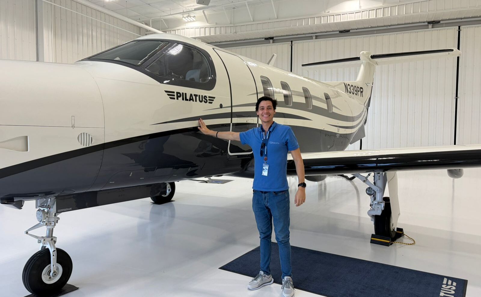 Pilatus PC-12 PRO aircraft, man stood in beside it touching the fuselage. 