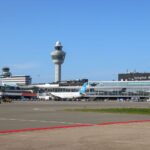 Amsterdam Schiphol Airport runway with control tower visible in the background