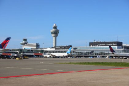 Amsterdam Schiphol Airport runway with control tower visible in the background