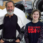 Omani and Jeanie Carson standing in front of an aircraft smiling.