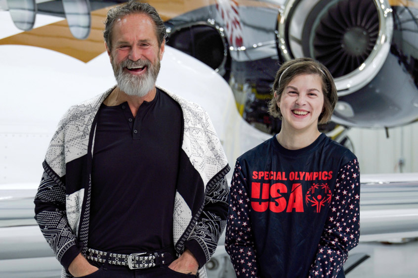 Omani and Jeanie Carson standing in front of an aircraft smiling.
