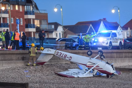 A light aircraft lying upside-down on a beach