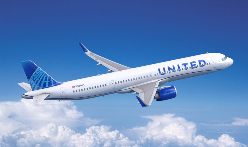 United Airlines plane in sky between blue skies and some clouds below.