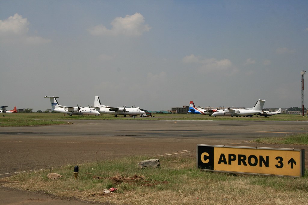 Parked aircraft lined up on the apron, sign for "apron 3" in the foreground.
