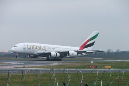 Emirates Lands at Manchester Airport, with grey skies in the background the Emirates bright logo standing out.