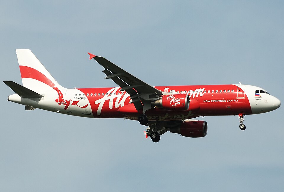 An eye-level, side-view photograph captures a Philippines AirAsia Airbus A320-216 in the final stages of its landing.