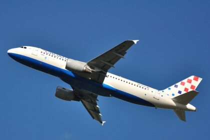 This low-angle shot captures a Croatia Airlines Airbus A320-214 (registration 9A-CTK) climbing steeply into a clear, deep blue sky after takeoff.