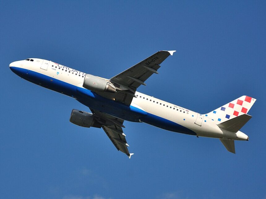 This low-angle shot captures a Croatia Airlines Airbus A320-214 (registration 9A-CTK) climbing steeply into a clear, deep blue sky after takeoff.