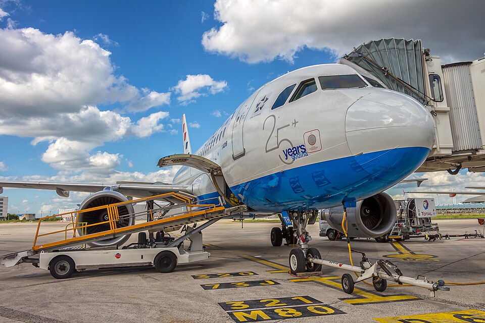 An eye-level, wide shot captures a Croatia Airlines Airbus A319-112 (registration 9A-CTH) parked on a bright, sunny day at an airport tarmac.