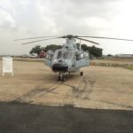 A head-on view of a light grey Harbin Z-9EH military helicopter parked on a tarmac under an overcast sky.