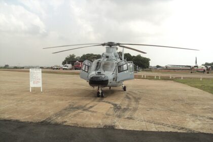 A head-on view of a light grey Harbin Z-9EH military helicopter parked on a tarmac under an overcast sky.