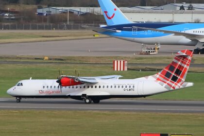 A Loganair ATR 72-600 turboprop aircraft, featuring its signature red-and-black tartan tail, taxies along an airport runway. In the background, the blue tail of a TUI Boeing 787 Dreamliner is visible