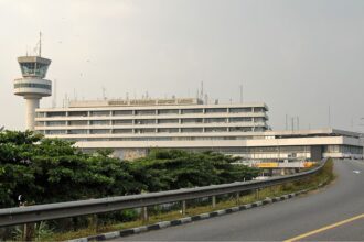External view of the Murtala Muhammed International Airport (LOS) terminal in Lagos, Nigeria, under a hazy sky