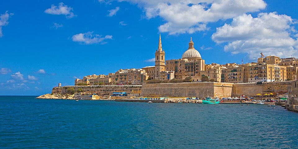  wide view of the historic city of Valletta, Malta, across a harbor. 