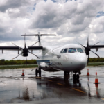A small white propeller plane sitting on airport tarmac