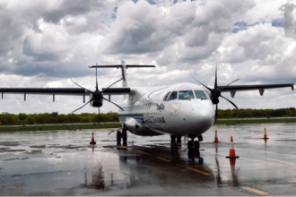 A small white propeller plane sitting on airport tarmac