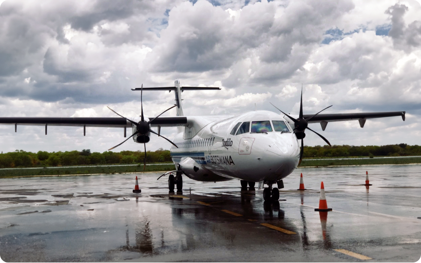 A small white propeller plane sitting on airport tarmac