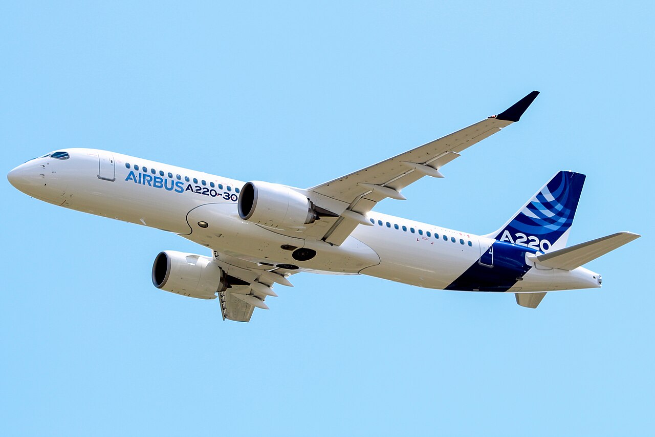 Airbus A220 aircraft flying in the blue sky.