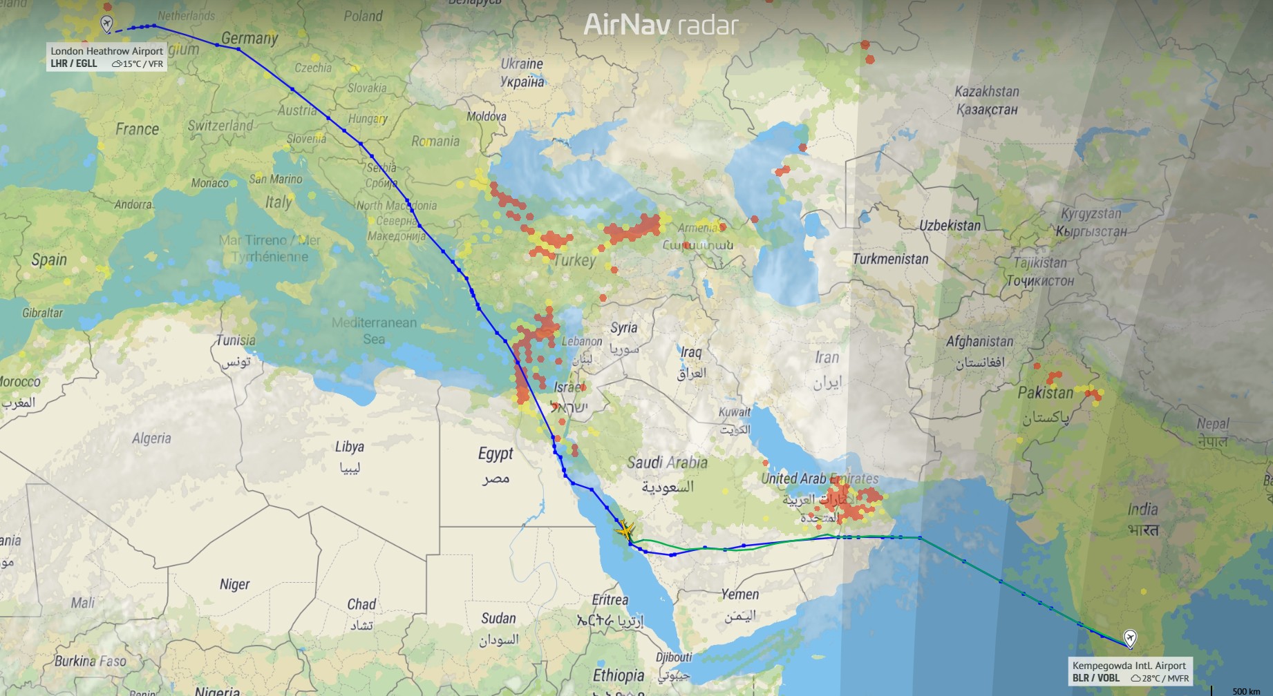 A detailed flight radar map from AirNav Radar shows a long-haul aircraft route stretching from London Heathrow Airport in Western Europe to Kempegowda International Airport in southern India. The path is drawn as a blue line curving southeast across Germany, the Balkans, and Turkey, then continuing over the eastern Mediterranean and the Middle East, passing near Israel and Saudi Arabia before crossing the Arabian Sea toward India.