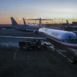 American Airlines aircraft parked at gates with the O'Hare control tower in the background.