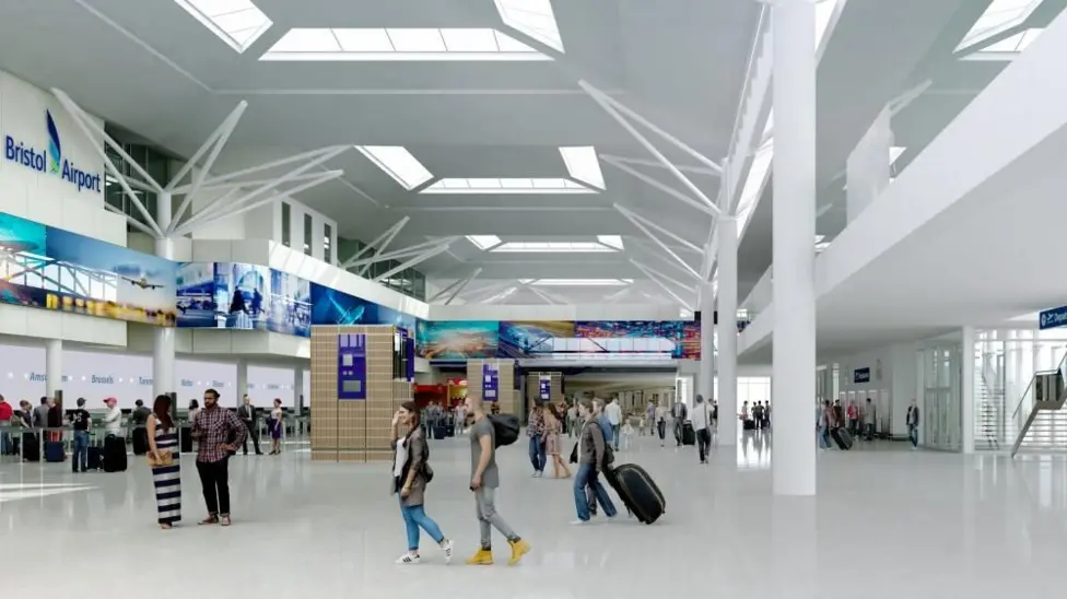 A white airport lobby with passengers walking around.